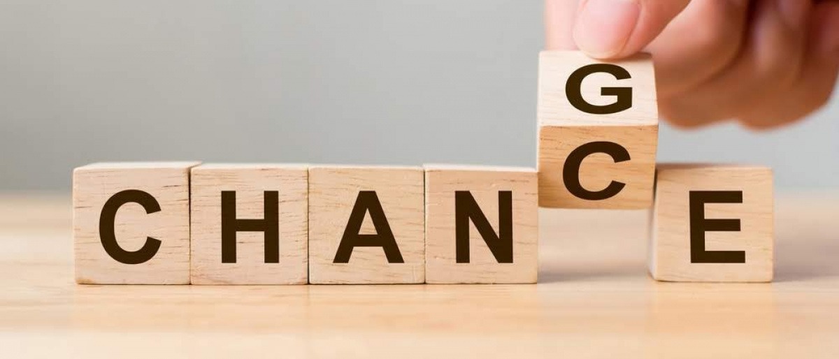 Das Wort Chance ist auf sechs Holzblöcken ausgeschrieben. Einer der Holzblöcke wird gerade umgedreht und man erkennt, dass auf der Rückseite der Buchstabe G ist, wodurch das Wort in den englischen Begriff change umgewandelt wird.