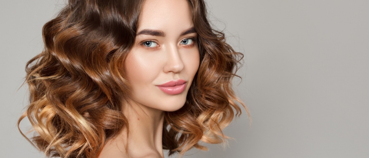 Frau mit mittellangen Locken.