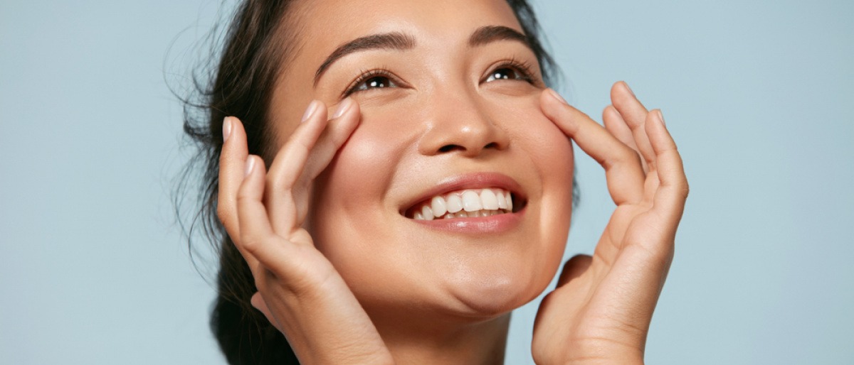 Eine Frau mit Make-up Cloud Skin lächelt 
