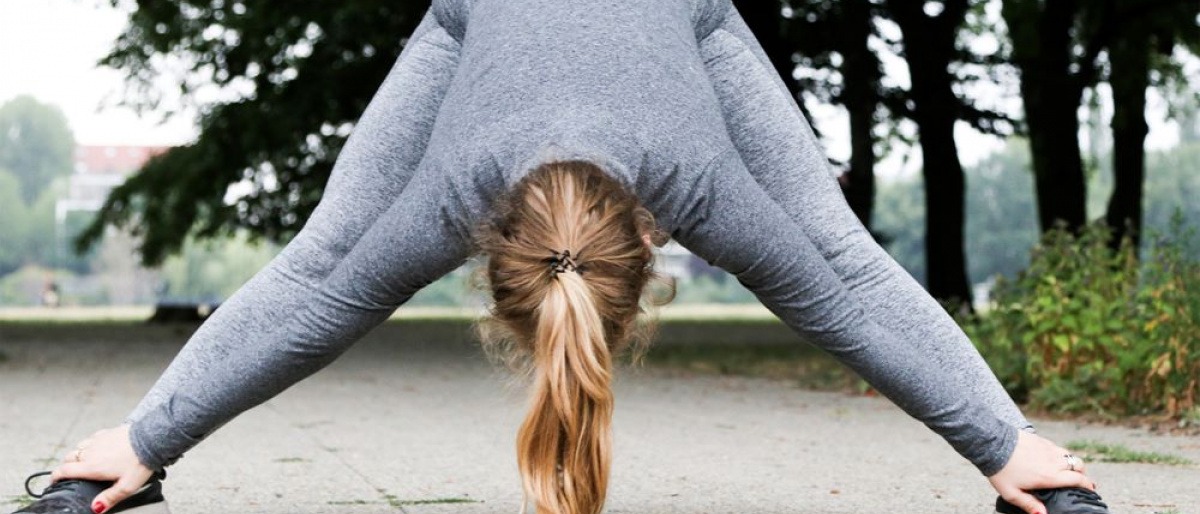 Eine Frau dehnt sich beim Joggen