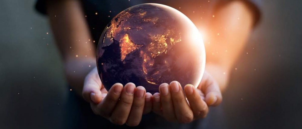 Eine Person hält eine Kugel, die dem Erdball gleicht, in der Hand. Die Kugel leuchtet von innen und soll symbolisieren, was es bedeutet, aktiv mit Energiearbeit lernen und leben zu wollen.