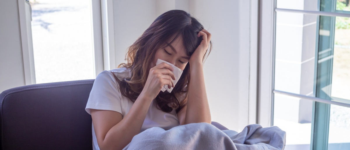 Eine Frau hat Erkältung oder Grippe mit Anzeichen Schnupfen