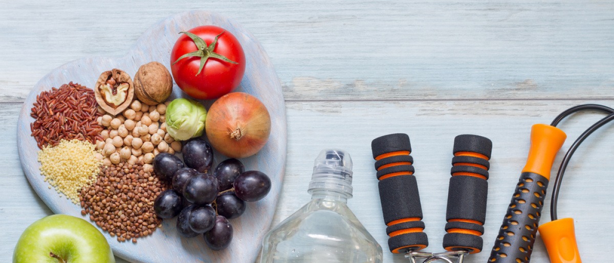 Obst für gesunde Ernährung liegt neben Sachen für Sport