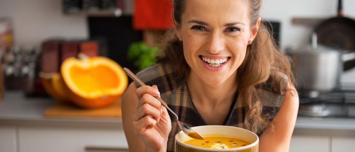 Frau isst Kürbiscremesuppe für Haarwachstum