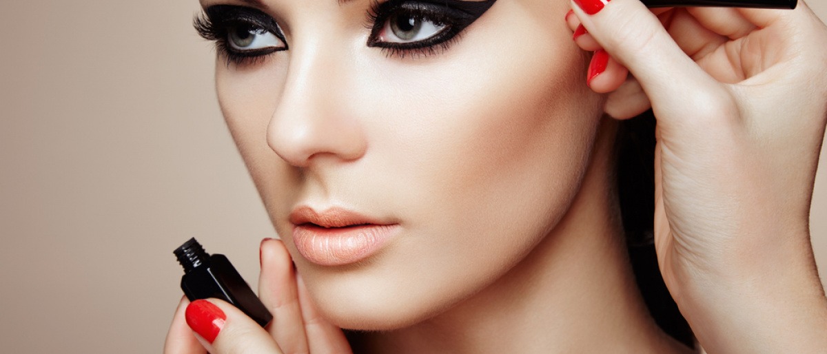 Eine Frau wird mit Eyeliner geschminkt