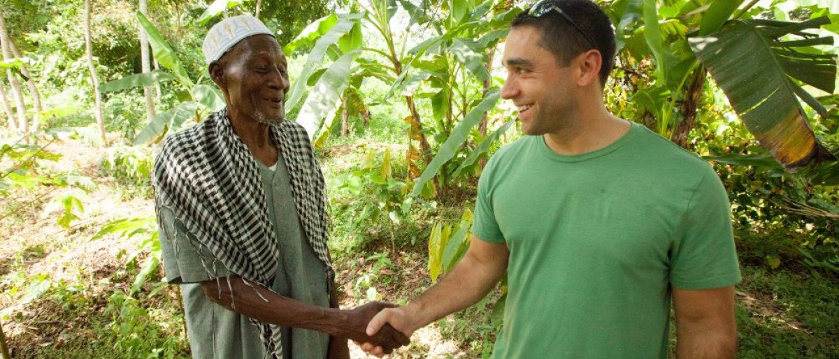 Ein Mitarbeiter von FAIRTRADE schüttelt einem FAIRTRADE-Produzenten die Hand