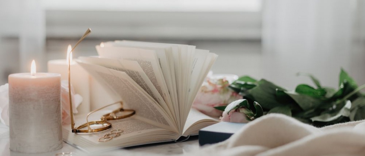 Ein aufgeschlagenes Buch, Ringe und Kerzen