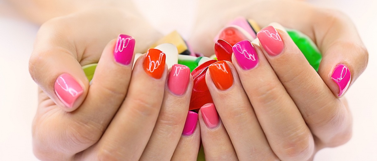 Fingernägel sind in Orange und Pink lackiert