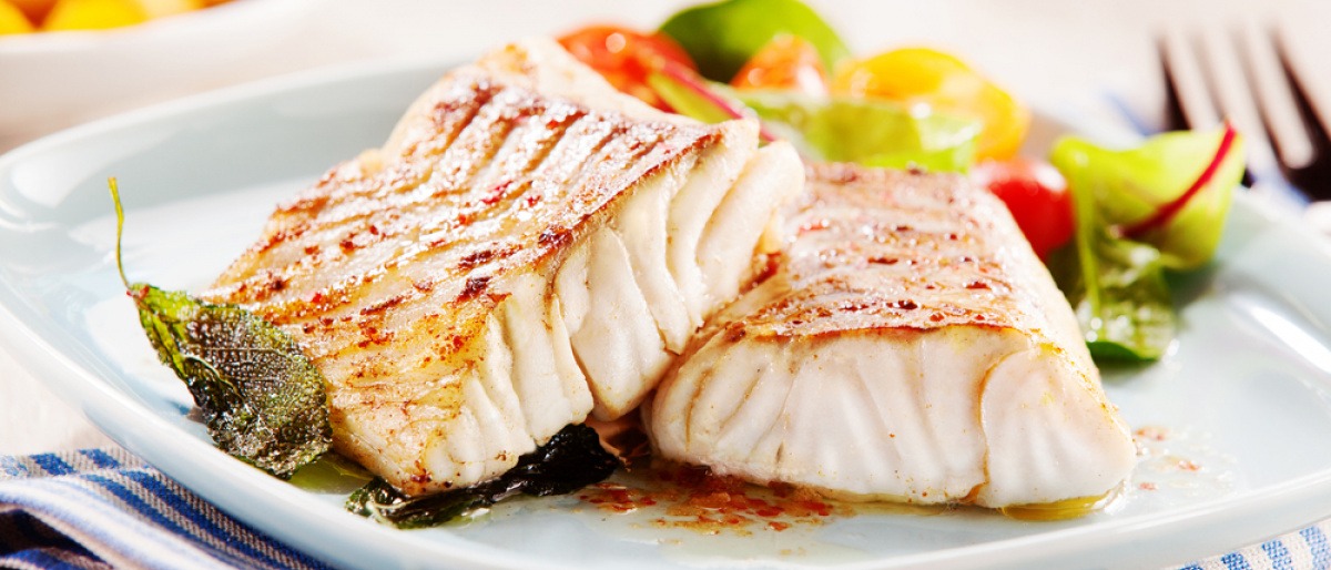 Ein Fisch für ein Gericht für mediterrane Küche liegt auf einem Teller