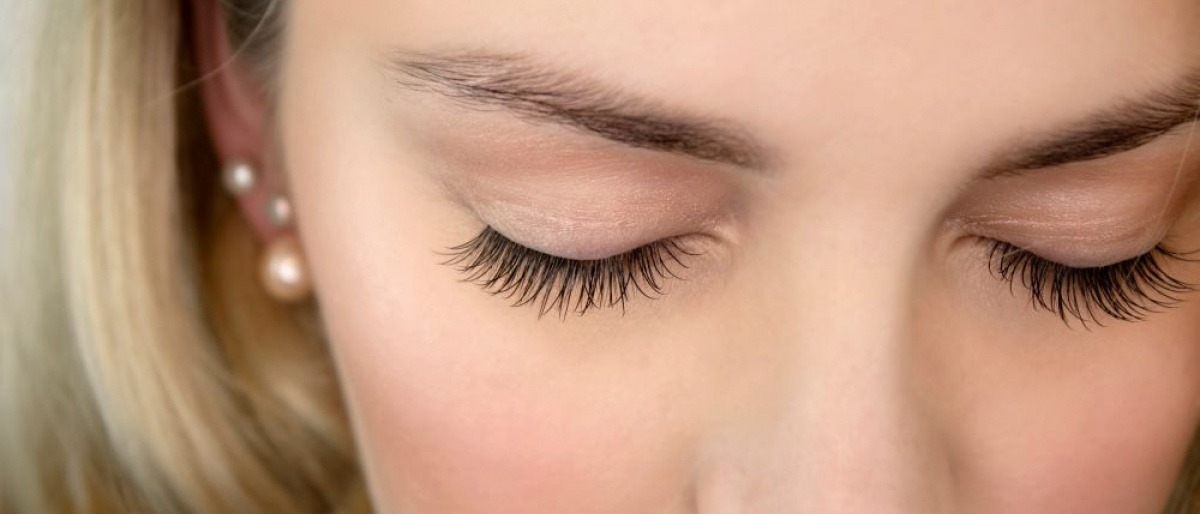 Ein blondes Mädchen mit Zahnspange hat lange Wimpern
