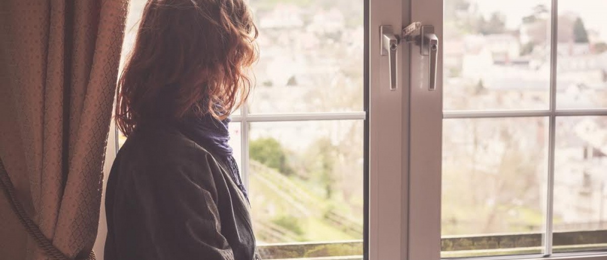 Eine Frau sieht aus dem Fenster