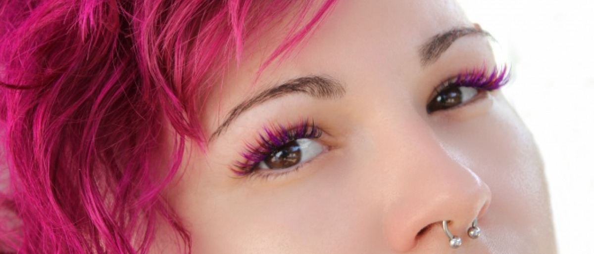 Eine Frau mit pinken Haaren hat pinke Wimpern.