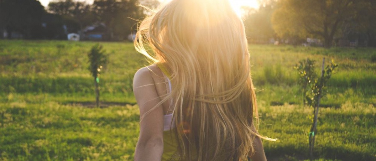 Eine Frau mit langen blonden Haaren befindet sich in der Natur