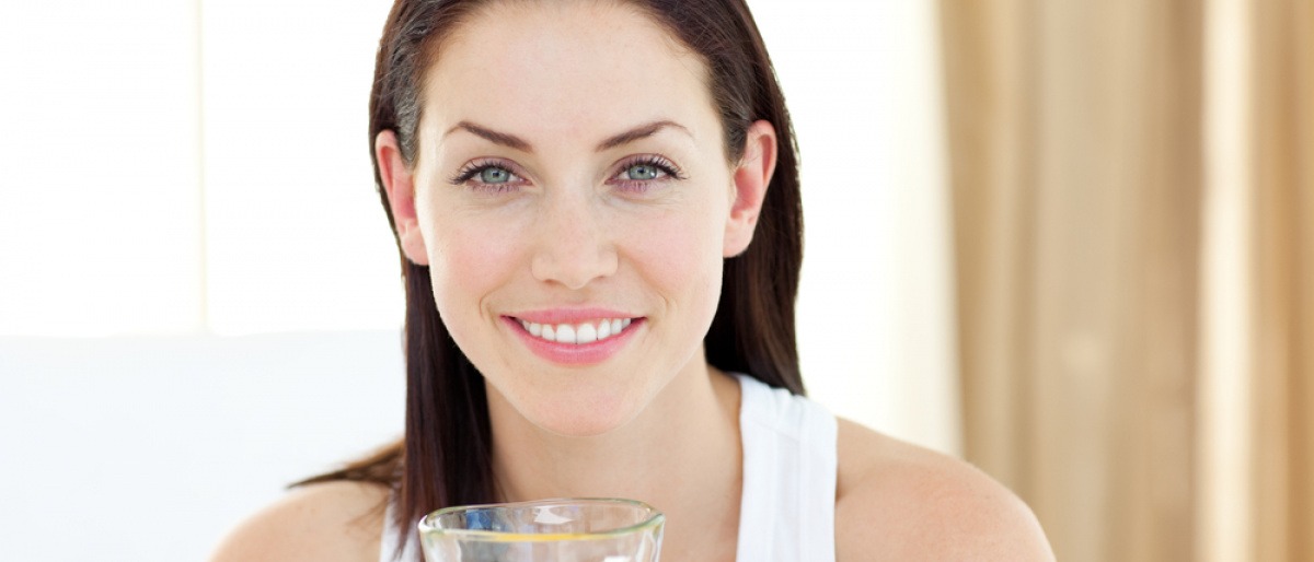 Eine Frau will fasten im Alltag und hält ein Glas Saft
