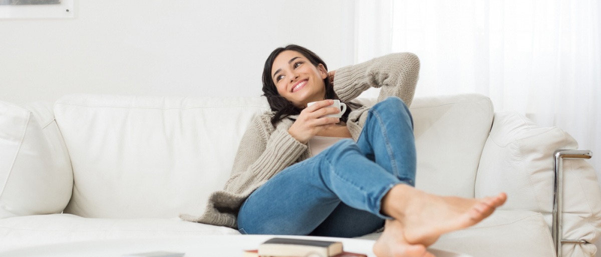 Eine Frau sitzt auf einem gemütlichen Sofa