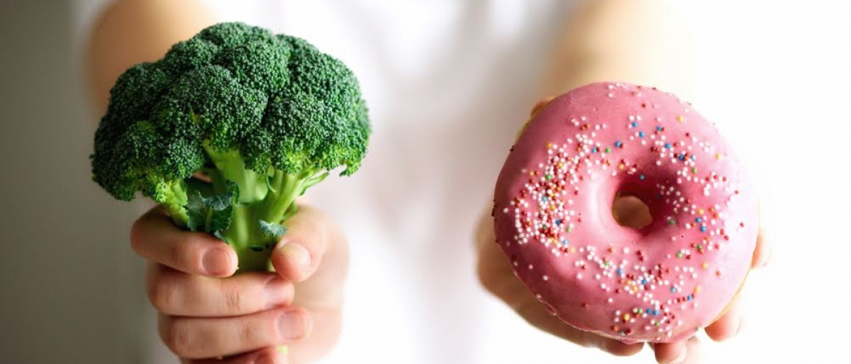 Eine Ernährungsberaterin zeigt ungesundes und gesundes Essen