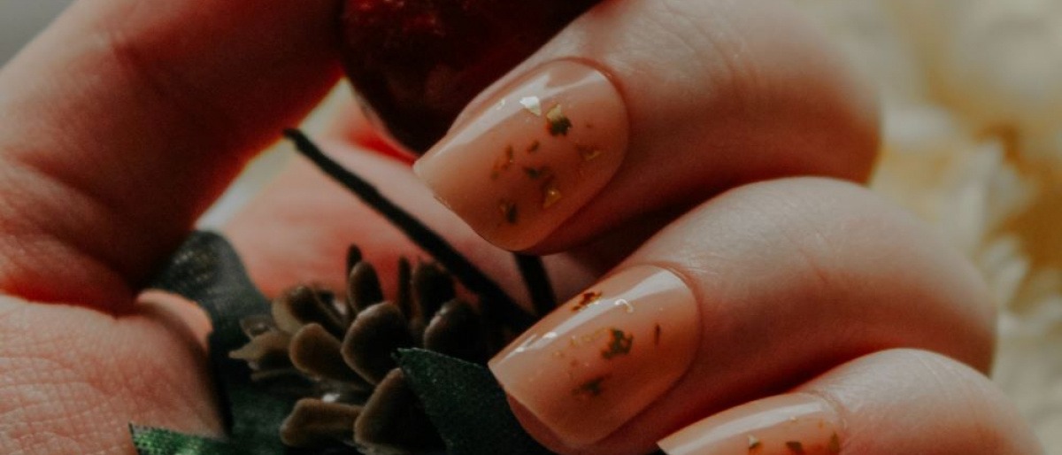 Hände mit Glass Nails halten eine Blume