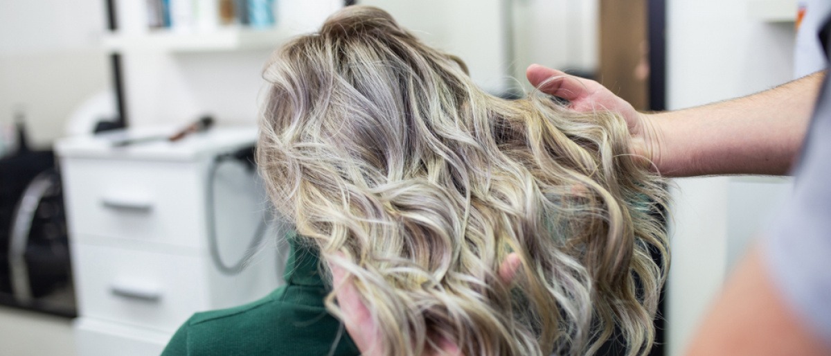 Eine Frau bekommt den Haarfarbentrend Grey Blending