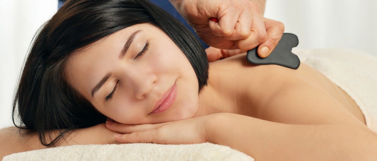 Eine Frau bekommt eine Gua Sha Massage