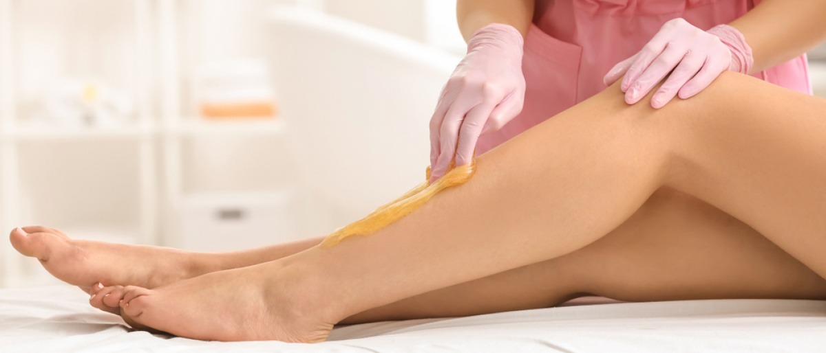 Haarentfernung mit Sugaring bei Beinen einer Frau