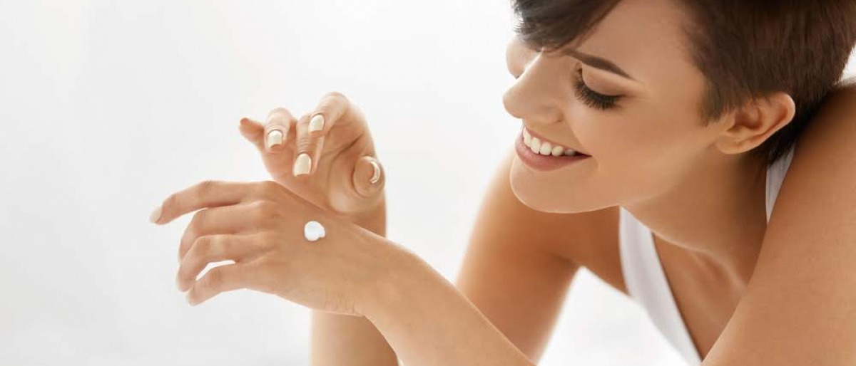 Frau mit Creme auf der Hand