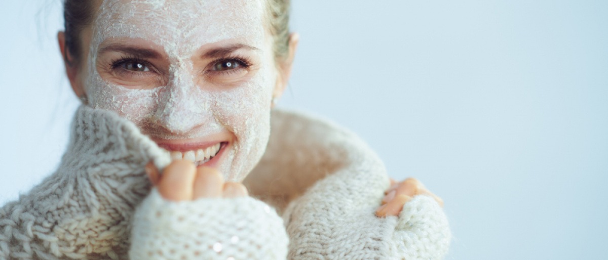 Frau mit Wollpulli und Hautpflege-Maske