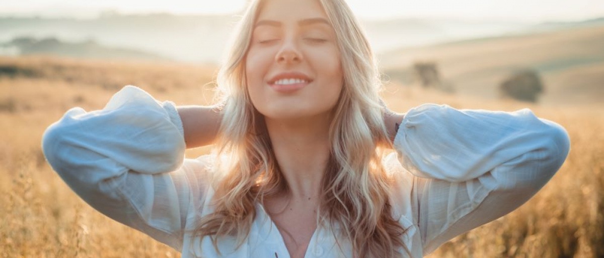 Eine Frau mit schöner Haut steht in der Sonne