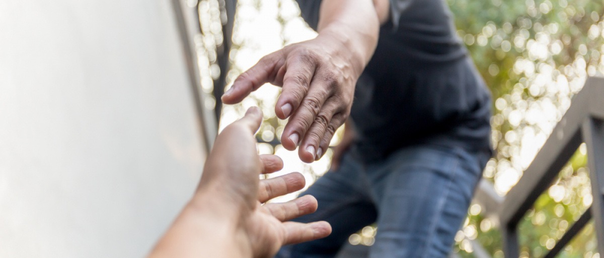 Eine Hand greift helfend nach einer anderen