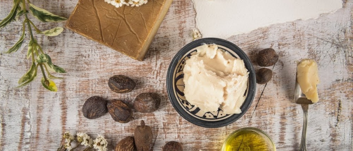 Sheabutter ist angerichtet, daneben liegen Nüsse