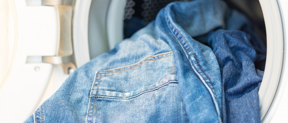 Jeans werden in Waschmaschine gegeben, um Jeans richtig zu waschen 