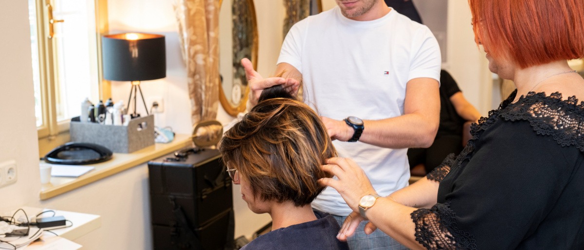 Frau bei Kopfhautberatung im Friseursalon.