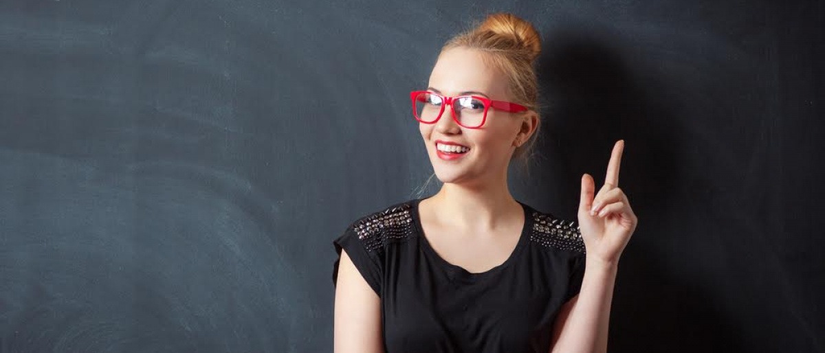 Eine Frau streckt den Zeigefinger in die Höhe und nutzt die Kraft der Gedanken