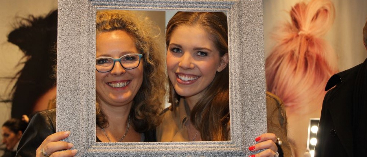 Zwei Frauen mit Luxuslashes halten einen Bilderrahmen