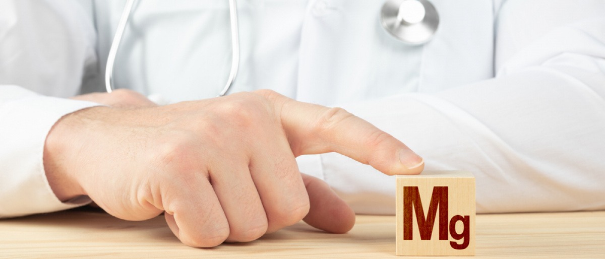 Arzt hält Würfel mit Mg (Magnesium)