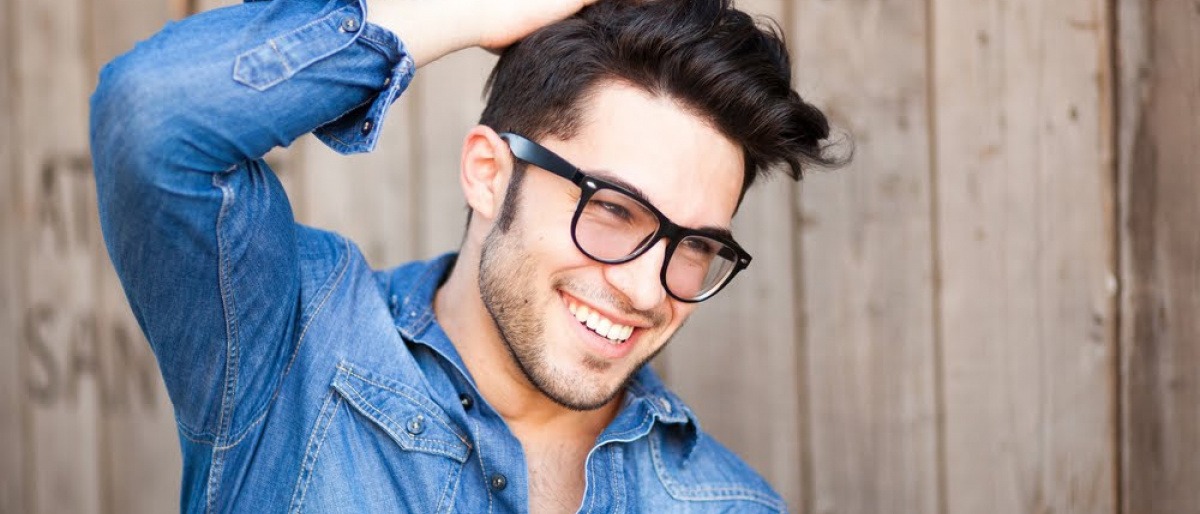 Junger Mann mit schönen Haaren und Brille.