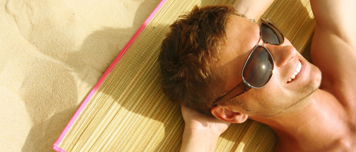 Ein Mann liegt in der Sonne am Strand