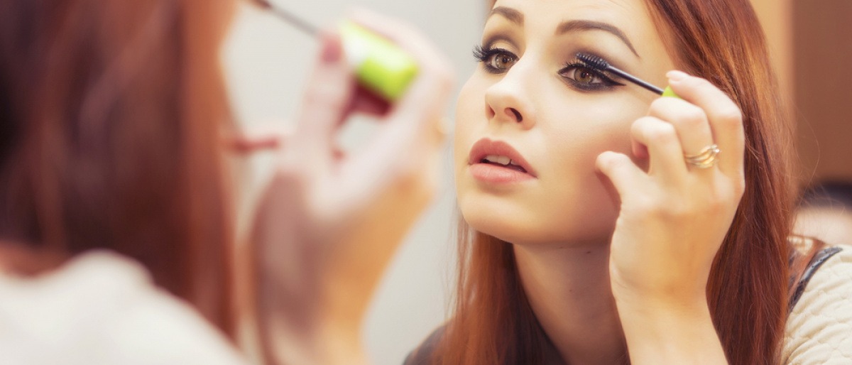 Frau schminkt sich mit Mascara