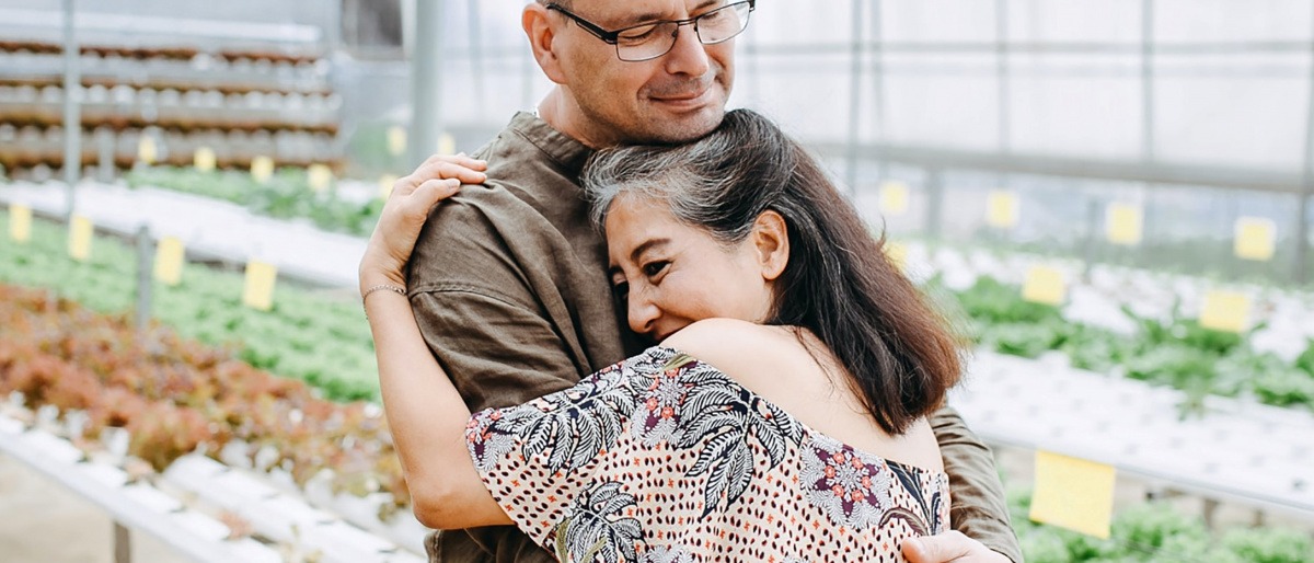 Ein Mann und eine Frau in der Midlife Crisis umarmen sich