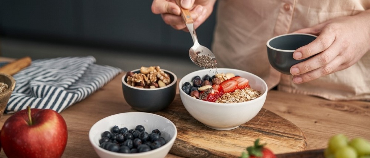 Müsli selber machen - junge Frau nascht aus einer Schale mit selbstgemachtem Müsli.