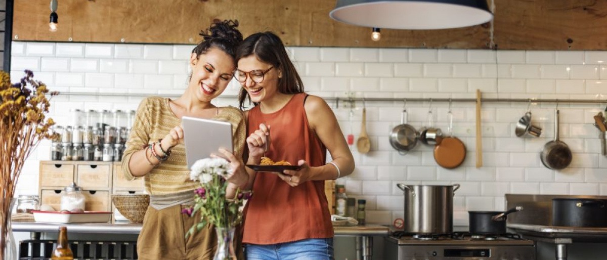 Nachhaltig zu kochen bedeutet, sich wie die Frau in diesem Bild an saisonalen und regionalen Lebensmitteln zu orientieren, die vor ihr auf dem Küchentresen liegen.