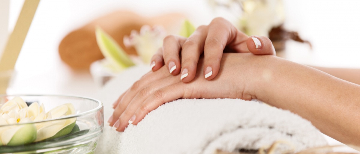 Hände mit gepflegten Fingernägeln liegen auf einem Handtuch
