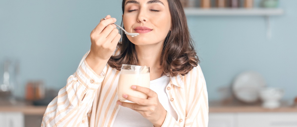 Frau isst Joghurt als probiotisches Lebensmittel