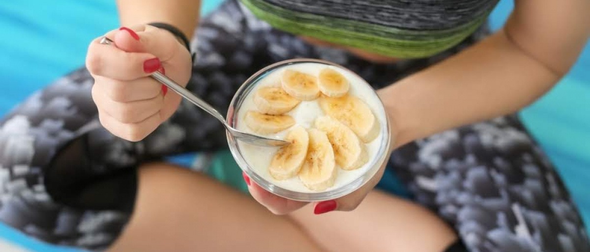 Frau isst Joghurt als probiotisches Lebensmittel