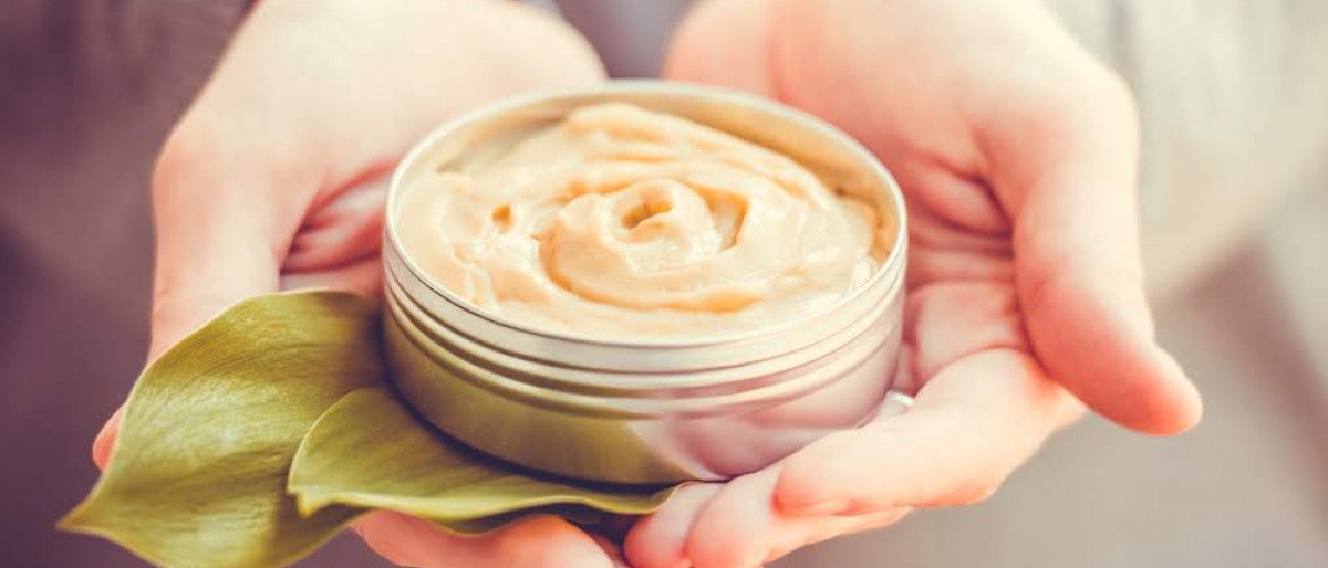 Eine Frau hält eine Q10 Creme in den Händen