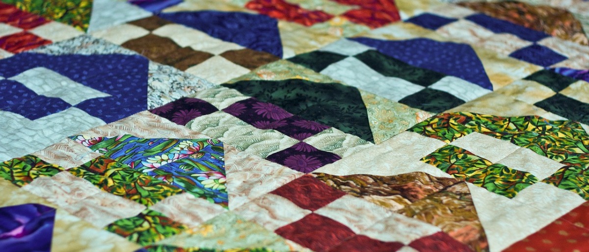 Quilten für Anfänger muss nicht schwierig sein. Das Bild zeigt eine farbenfrohe Patchwork Decke.