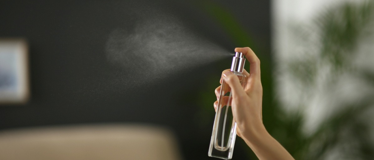 Frau sprüht Raumspray