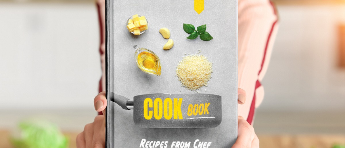 Frau hält selbst erstelltes Rezeptbuch in die Kamera