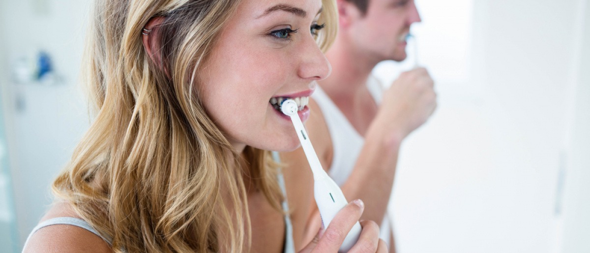Ein junges Paar putzt sich die Zähne.