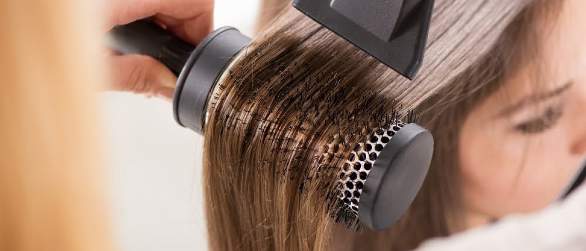 Haare werden mit einer Rundbürste geföhnt