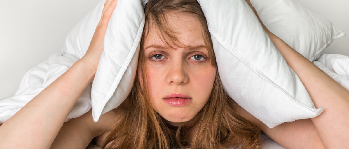Eine Frau mit Schlafstörungen hat das Kissen am Kopf